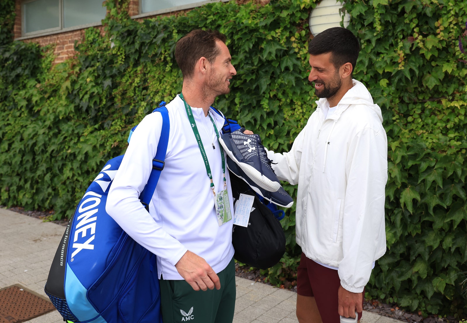 Image may contain Novak Djokovic Clothing Coat Adult Person Accessories Bag Handbag Footwear Shoe Shirt and Face