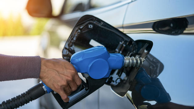 Pumping gas at gas pump. Closeup of man pumping gasoline fuel in car at gas station. 