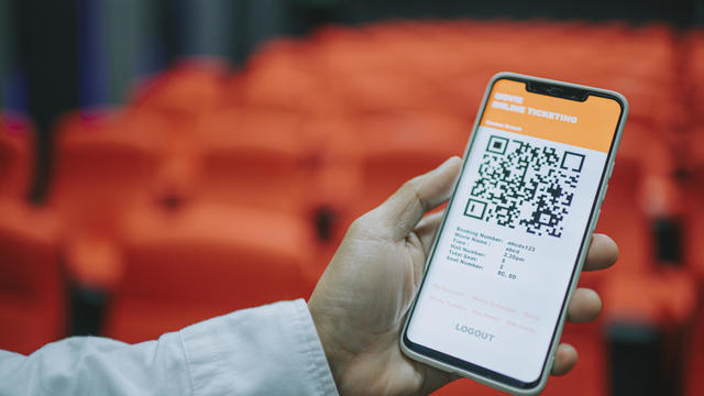 asian chinese man using mobile app cinema movie e-ticketing reservation looking for seat inside cinema hall 