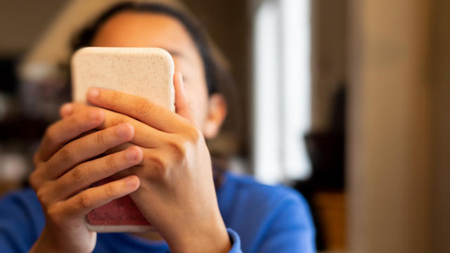 Teen looking at social media on a cellphone 