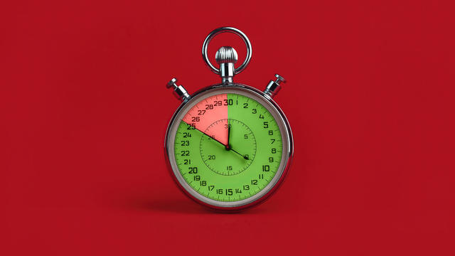 stopwatch with colorful segments on red background. Interest-free period concept 