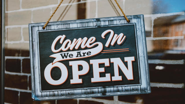 Open Sign Hangs From Store's Door 