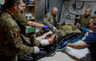 Medics help a wounded Ukrainian serviceman inside a medical stabilisation point near the town of Chasiv Yar, in Donetsk region 