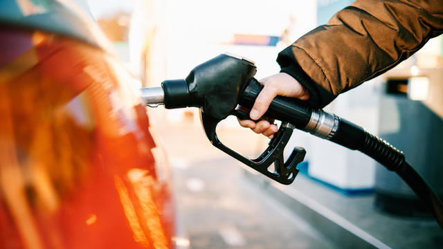 close-up of a hand in a gas pump fueling a car during energy crisis 