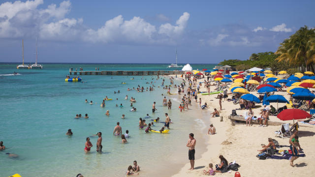 People relax and swim at Doctor's Cave beach 