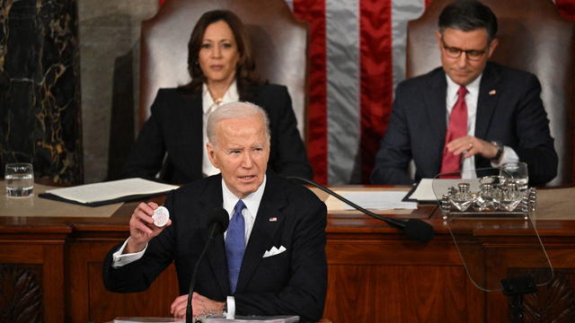 President Biden holds a button with Laken Riley's name on it while delivering the State of the Union address on March 7, 2024. 