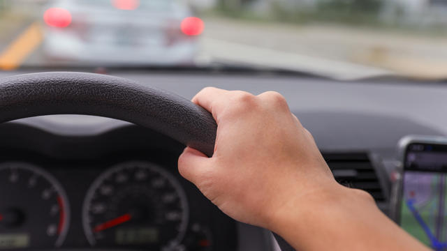 hand grips a car steering wheel, symbolizing safe and controlled driving, with a focus on responsibility and road safety 