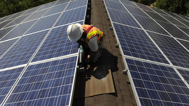 Dave Cook, a Solar Panel installer with Bella Energy, finishes installing panels on the roof top of 1535 Spruce Street in Boulder.The sudden suspension and lower incentive rates of Xcel Energy's rebate program has drastically impacted solar installation c 