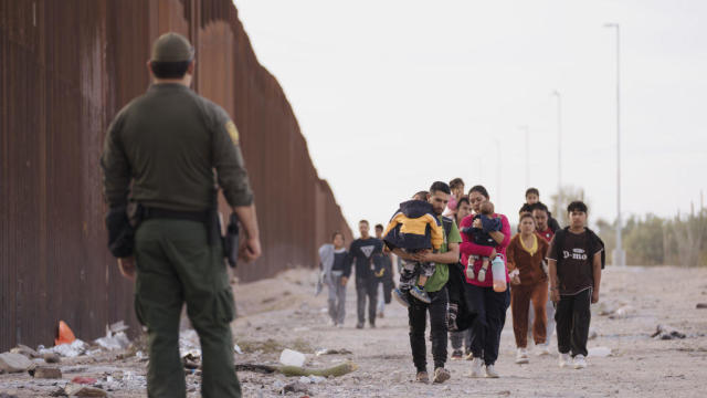 A Customs and Border Protection officer near migrants at the U.S.-Mexico border in Lukeville, Arizona, on Monday, Dec. 11, 2023. 