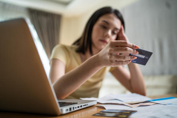 Depressed Asian young girl feel worry about financial problem in house. Stressed desperate young woman looking frustrated to paperwork and bills think of money debt, budget loss, bankruptcy at home. 