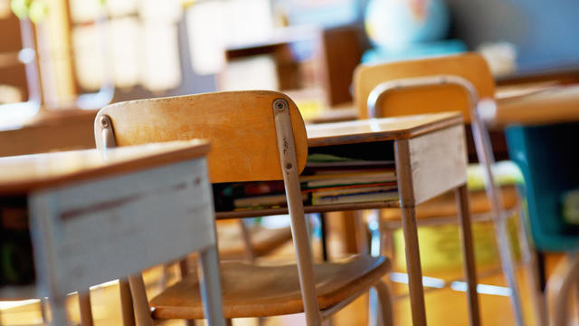 Classroom with empty wooden desks 