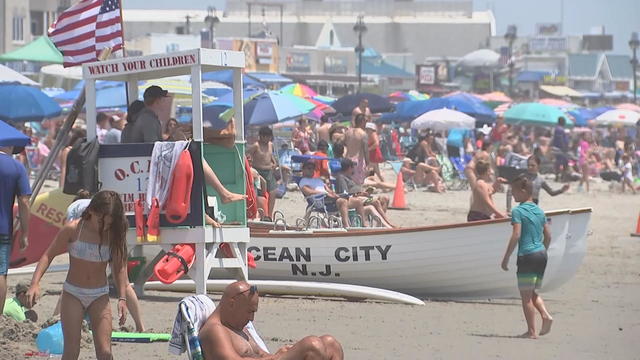 Families on the beach near an Ocean City lifeguard stand and beach patrol boat 