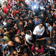 bollywood actor surrounded by adorning fans as they all look up to a camera overhead