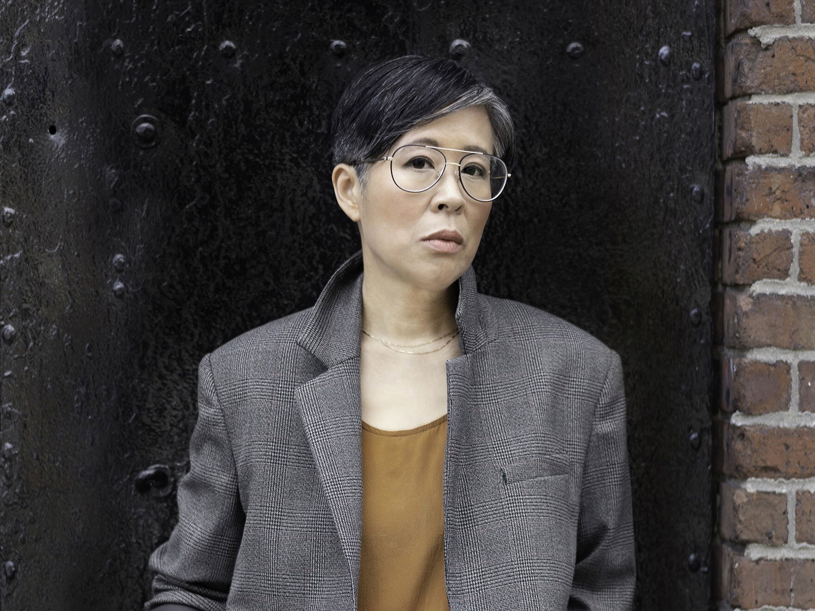 A headshot of Lisa Ko wearing a grey blazer and glasses