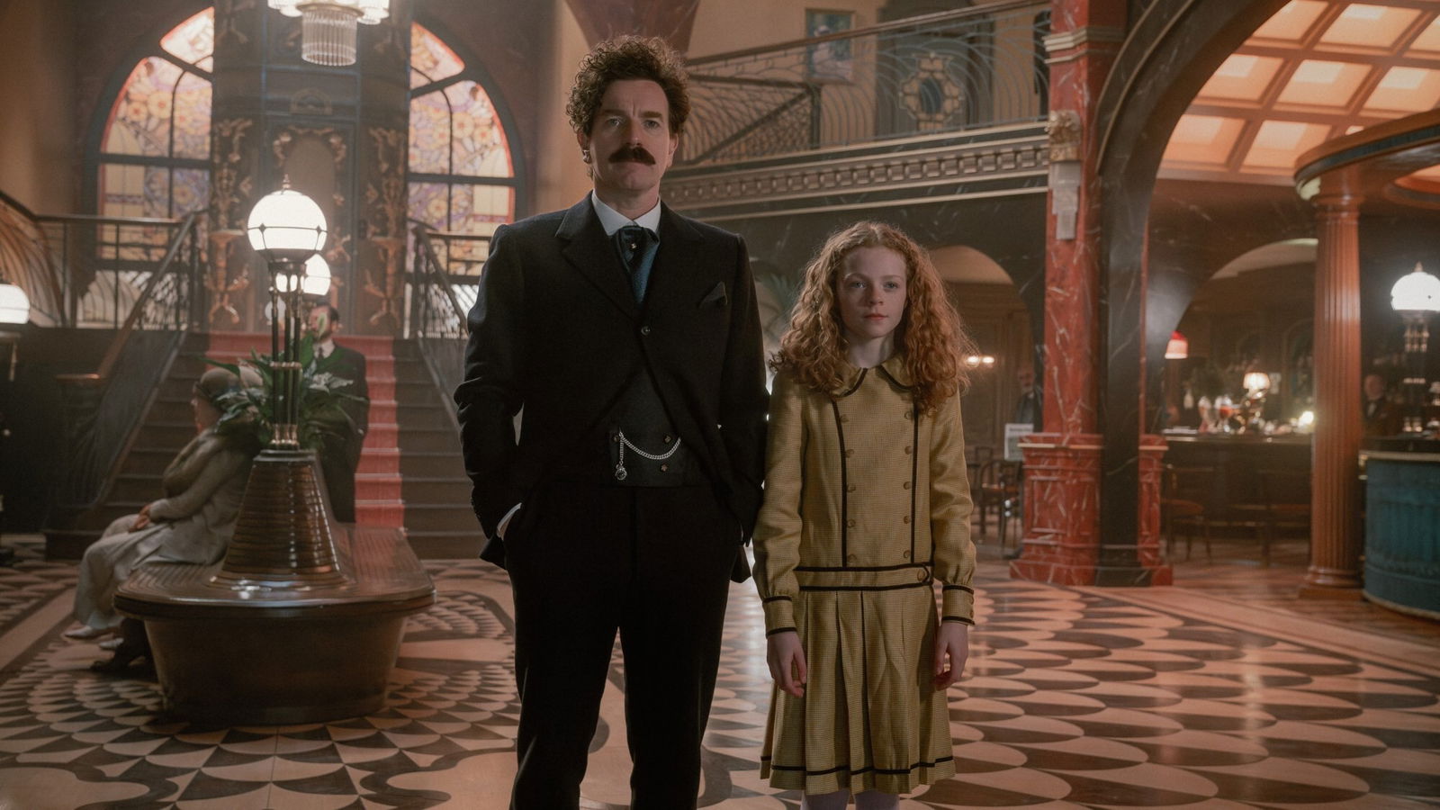 A man stands in a hotel foyer with a young girl