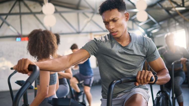 A person works out on an air bike in the gym.