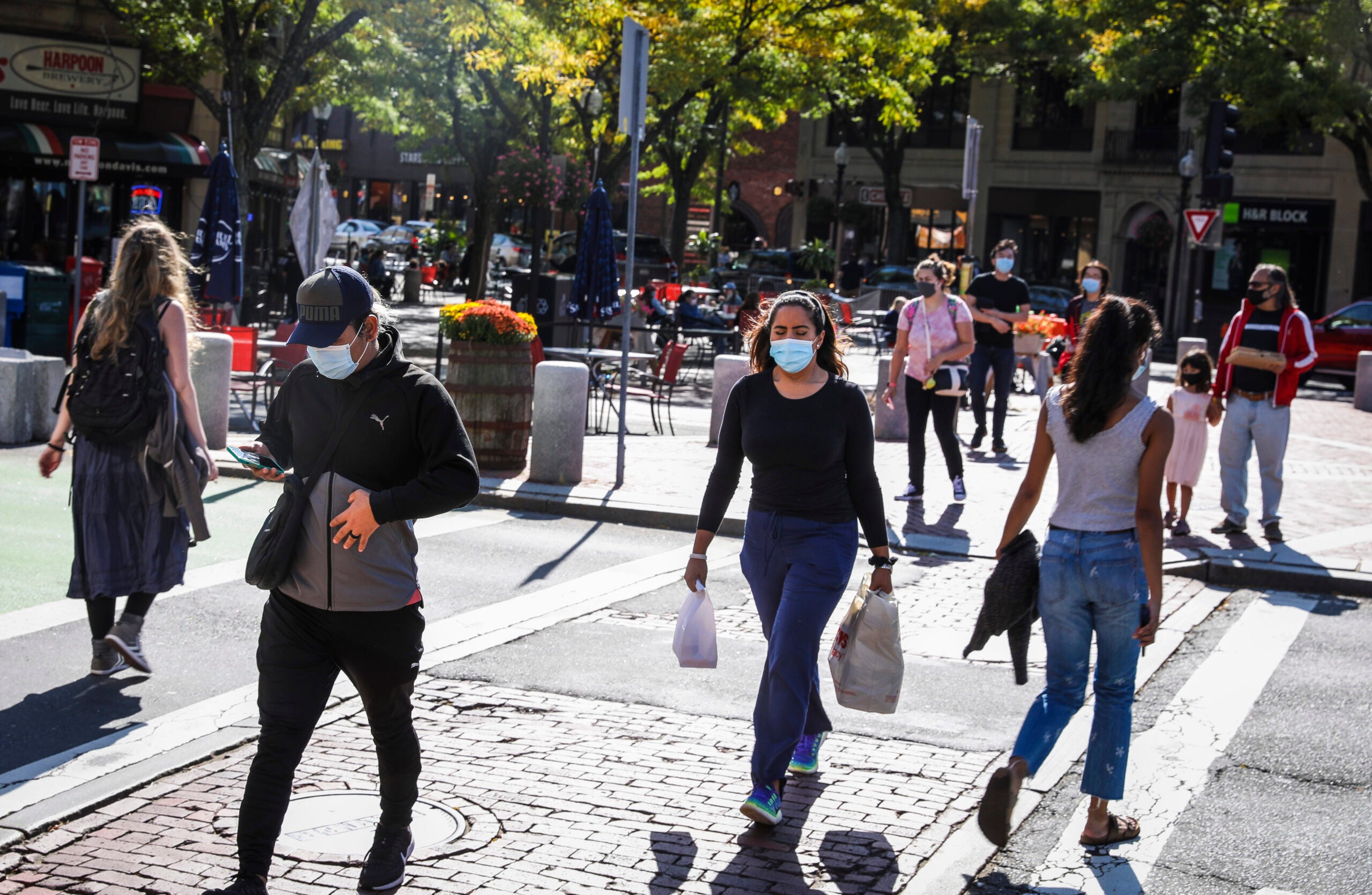 People cross the street in Somerville's Davis Square.