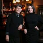 Todd and Victoria Horvath pose for a photo inside their new bar, The Hidden Door.