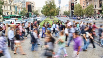 a large group of people crossing a city crosswalk