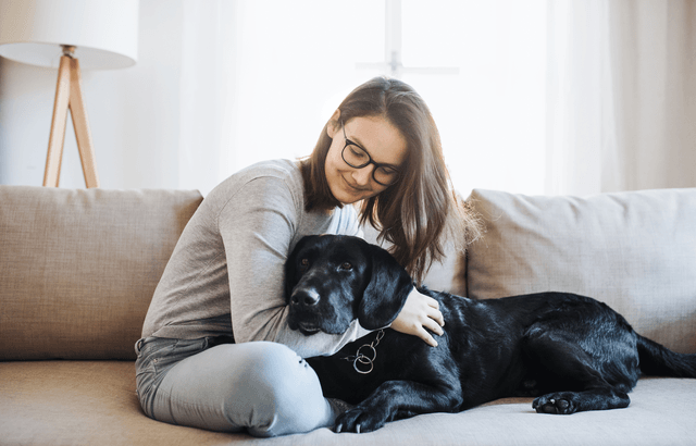 Woman cuddling pet in apartment.