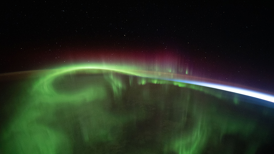 A aurora vividly streams over the Earth as the station orbited above the southern Indian Ocean in between Australia and Antarctica.