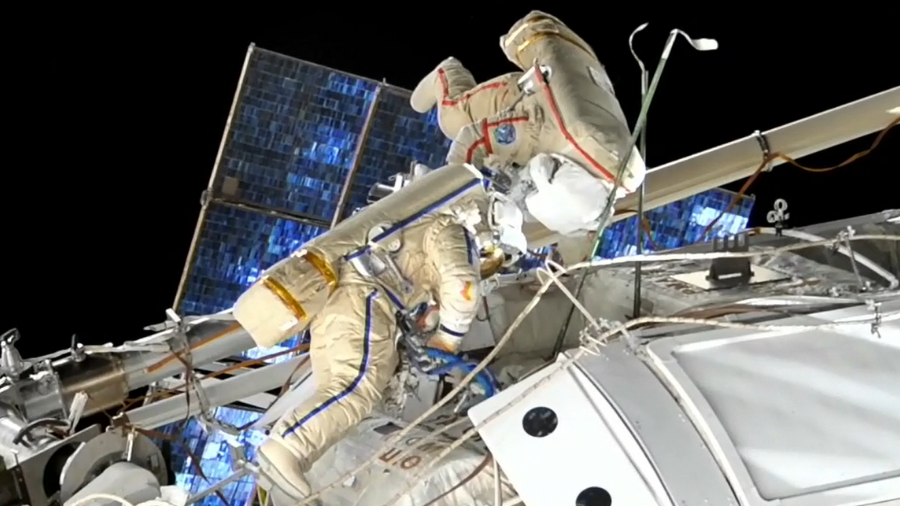 Roscomos cosmonauts Sergey Prokopyev and Dmitri Petelin are seen at work during a spacewalk on Nov. 17, 2022. Prokopyev is in the suit with red stripes and Petelin is in blue.