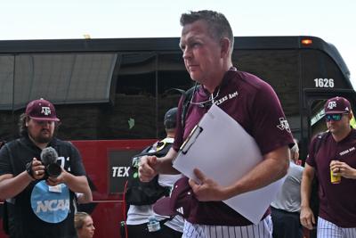 Texas A&M head coach Jim Schlossnagle leads his team off the team bus, arriving to play Tennessee at the NCAA Division I Baseball Championship on June 23, 2024, at Charles Schwab Field in Omaha, Nebraska.