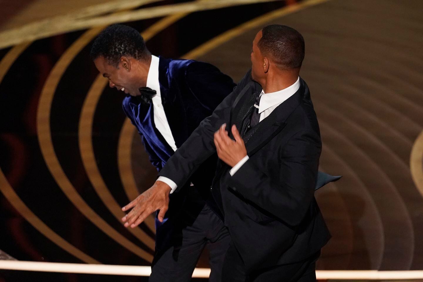 Will Smith hits presenter Chris Rock on stage while presenting the award for best documentary feature at the Oscars on Sunday in Los Angeles.