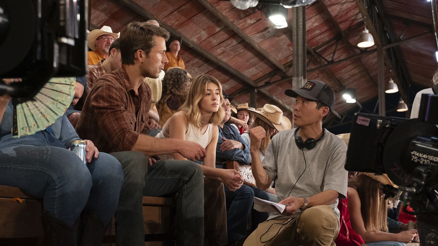 This image released by Universal Pictures shows Glen Powell, left, and Daisy Edgar-Jones, center, with director Lee Isaac Chung on the set of "Twisters."