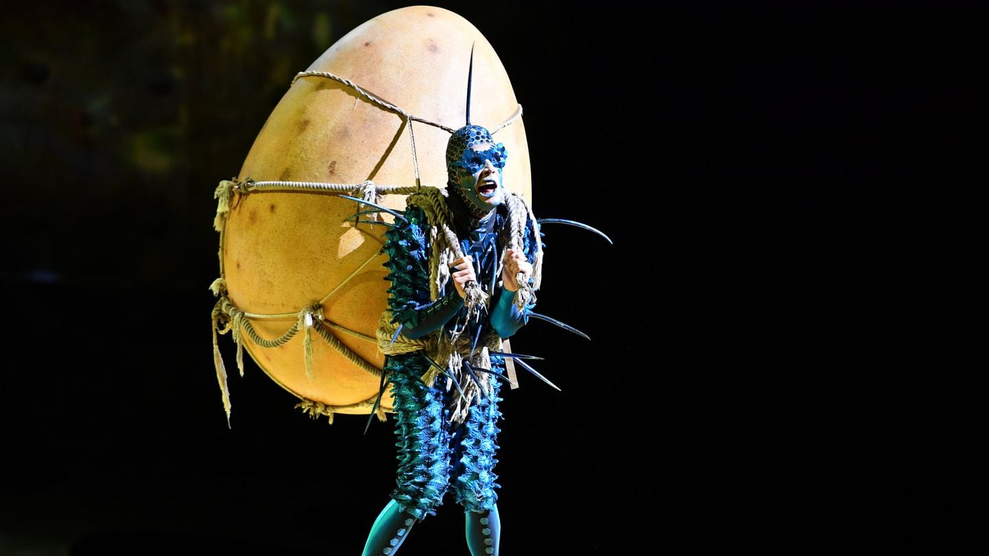 A blue fly character called The Foreigner guards the mysterious egg that is his prized possession in a scene from Cirque du Soleil's "OVO."