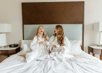 Friends enjoying coffee in bed.