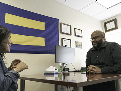 Larry and Jasmine speaking in an office