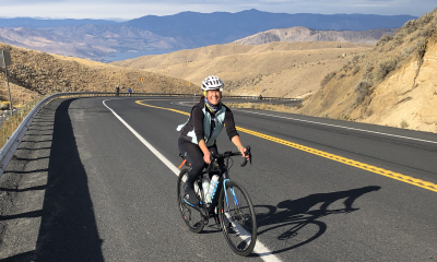 A person bikes past beautiful Lake Chelan and the rolling hills