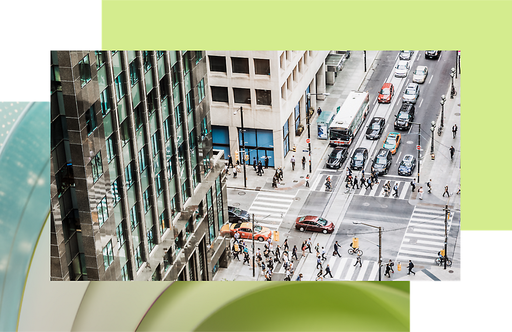 Aerial view of a busy city intersection with cars, buses, and pedestrians, highlighting bustling urban life.