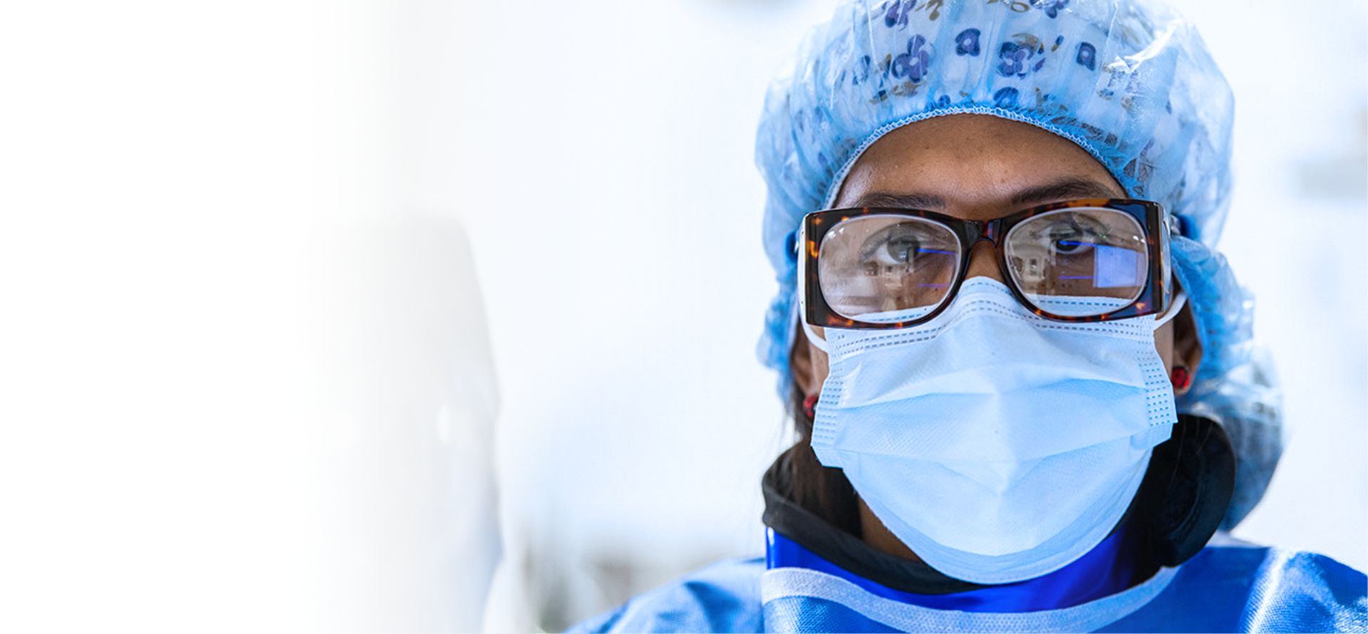 a close up of a masked doctor wearing glasses and a hairnet