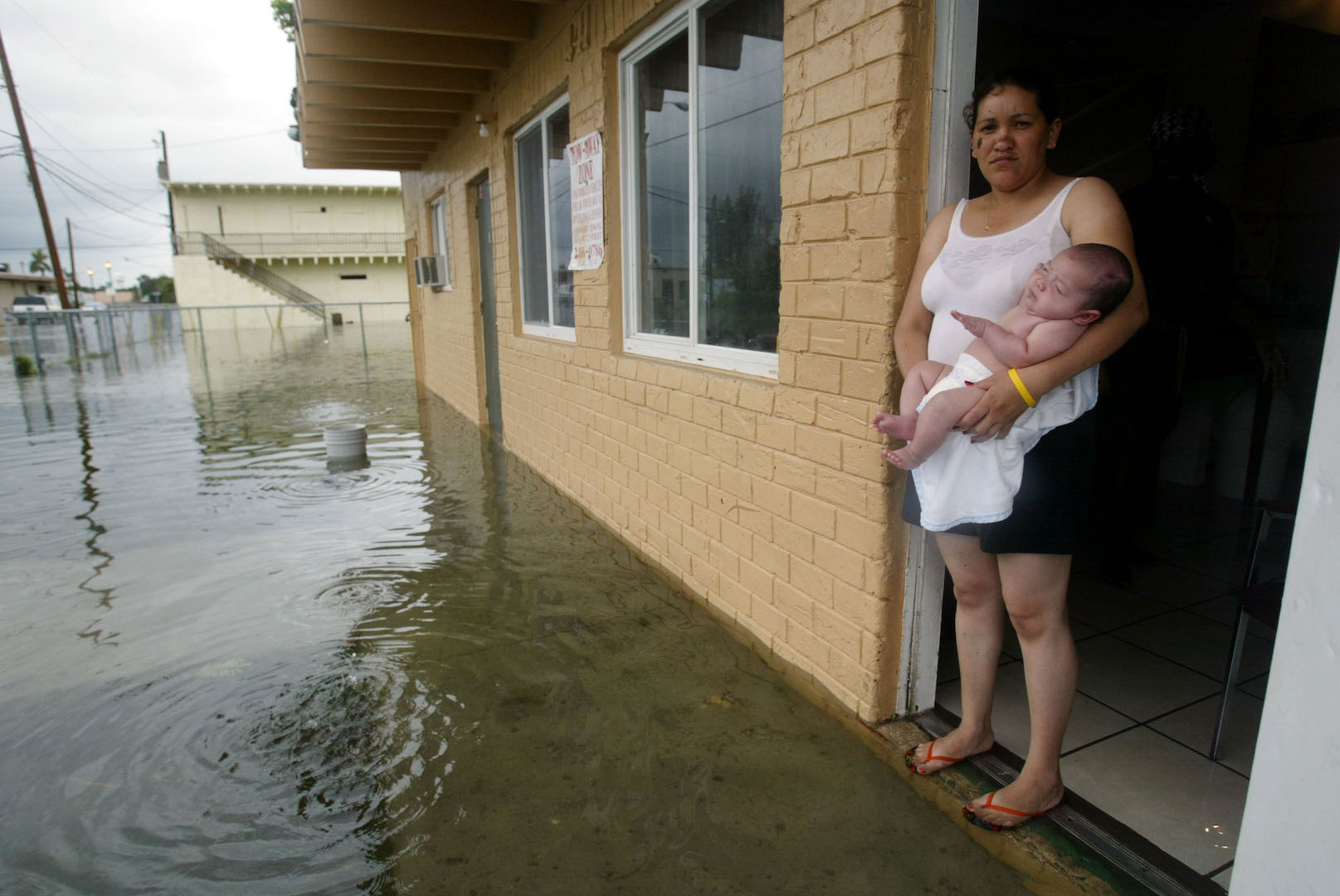 Vilma Nelasgor holds her baby, Roger, as they stand in the door of their Homestead, Fla., Aug. 26, 2005 after Hurricane Katrina dumped several inches of rain in south Florida.