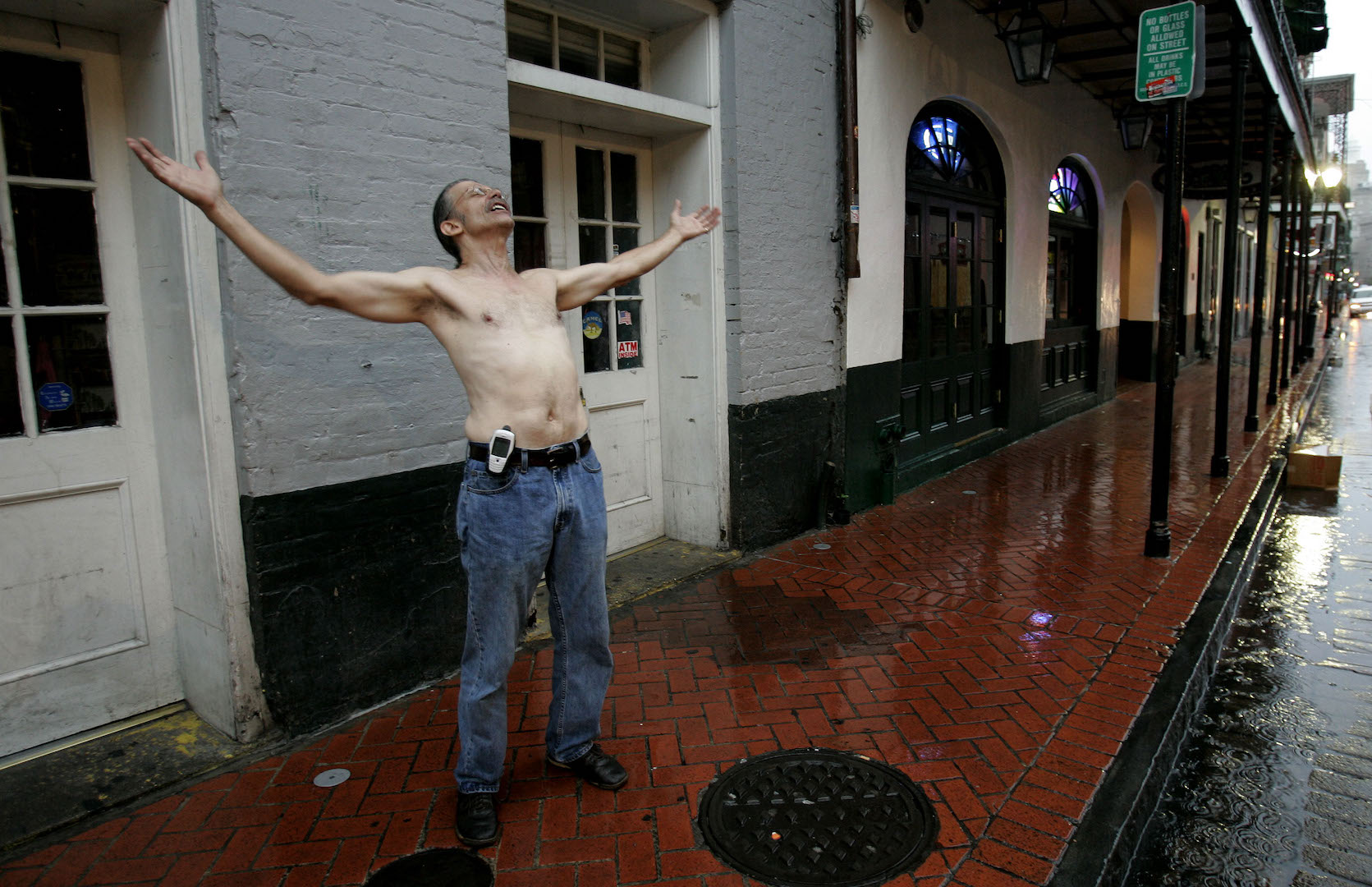 Vaugh Mordenti sings to a friend as he stands in the rain on Bourbon Street in the French Quarter as Hurricane Katrina nears New Orleans, Sunday, Aug. 28, 2005.