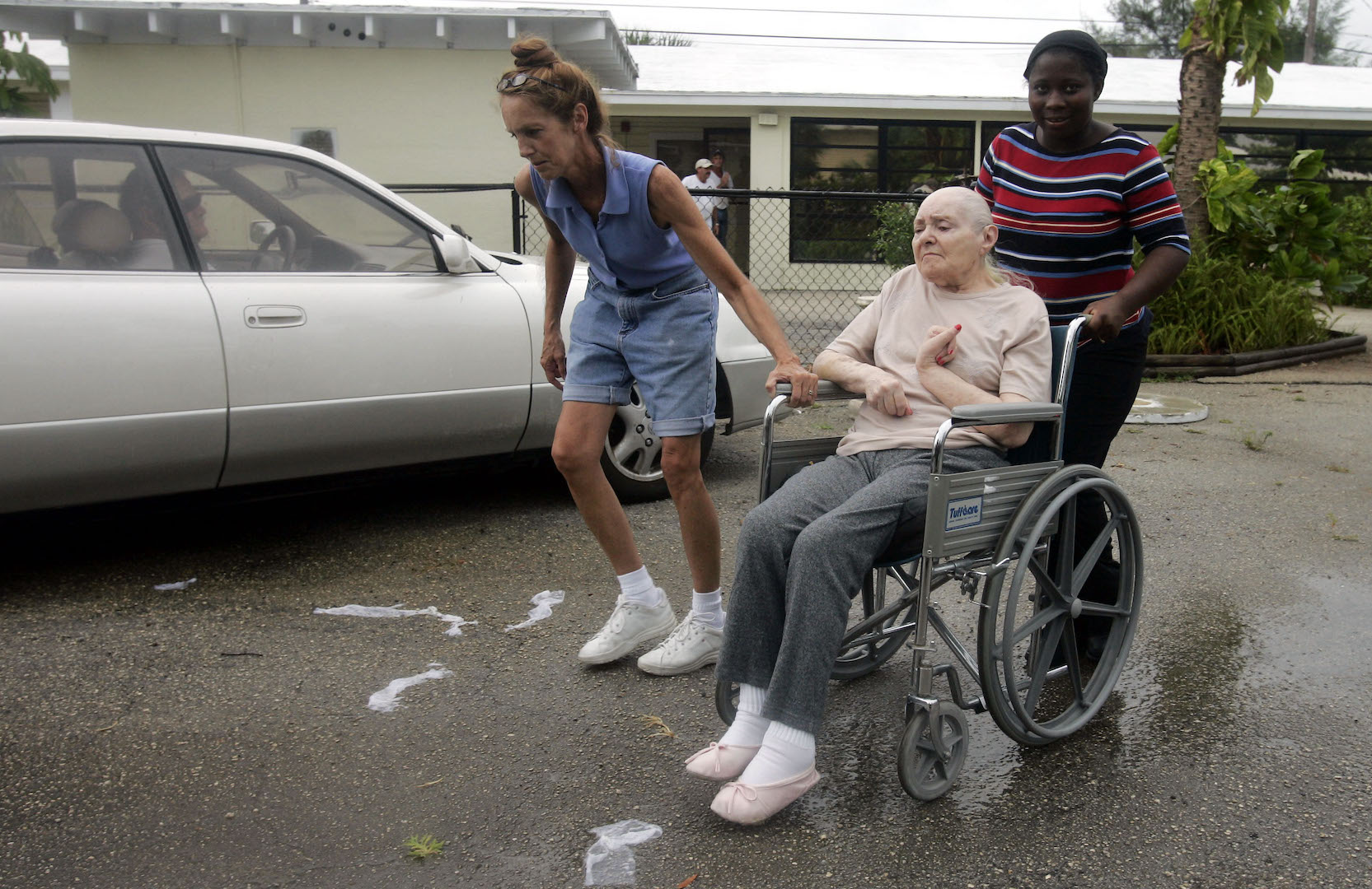 June Trach and Anestal Elmitor push Syvlia Tunis to a waiting car that will take her to another retirement center in Boynton Beach, Fla., Aug. 25, 2005 as Katrina approaches.