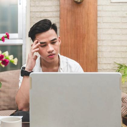 Man looking frustrated at laptop