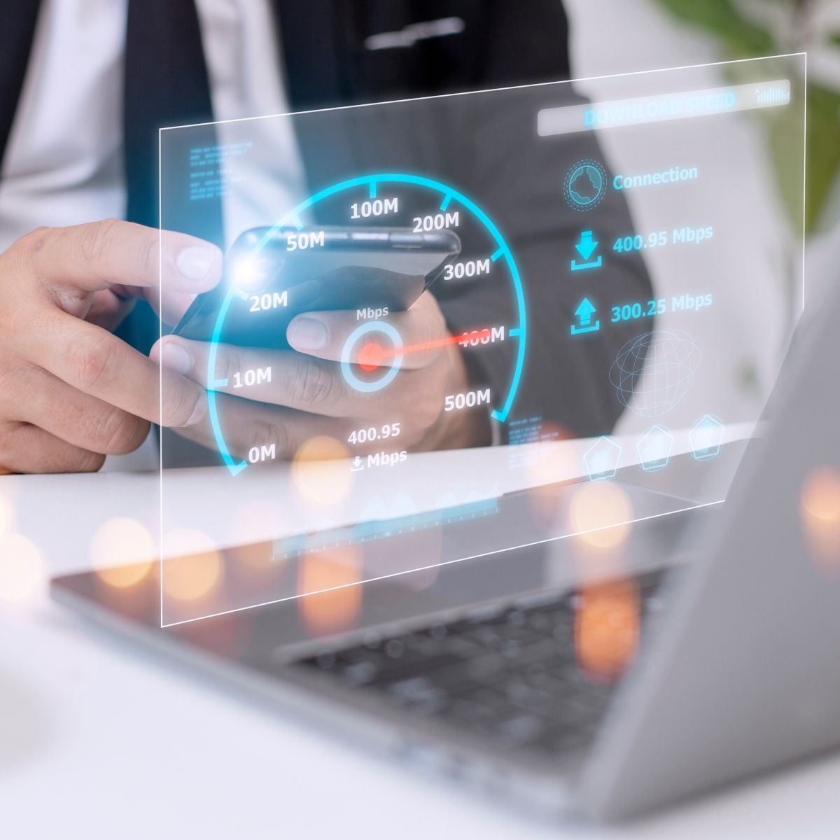 Man wearing suit using phone and laptop with hovering digital imagine above keyboard showing speed test levels