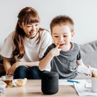 A young boy interacts with a smart speaker