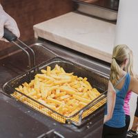 Franchise Costs. composite image: Dance instructor in front of class, french fries in commercial fryer.