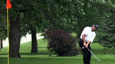 Golf. Putt. Putter. Sports. Pro tournament golfer pitching on the green with the pin in the hole.