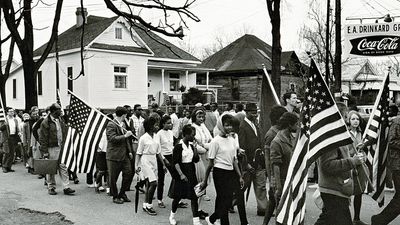 Participants, some carry American flags, march in the civil rights march from Selma to Montgomery, Alabama, U.S. in 1965. The Selma-to-Montgomery, Alabama., civil rights march, 1965. Voter registration drive, Voting Rights Act