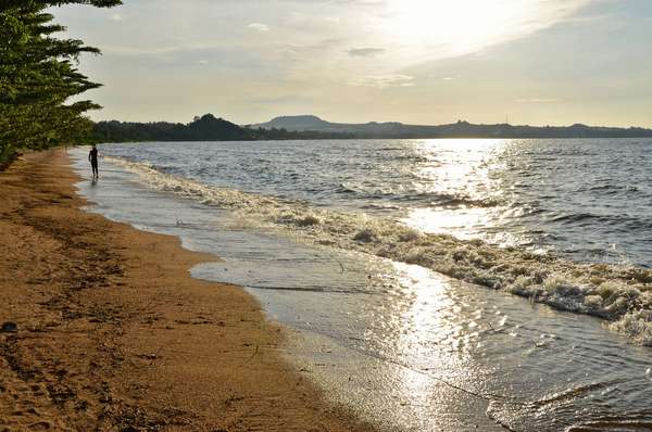 A man walks on the shore of Lake Victoria in Tanzania.