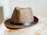 A mens hat resting on fabric. trilby