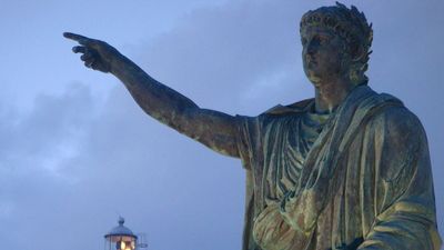 Statue of of the Roman emperor Nero with the lighthouse in the background at Anzio, Lazio region, Italy