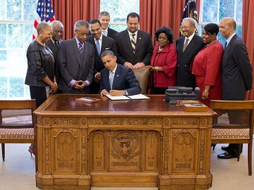 President Barack Obama signs the White House Initiative on Educational Excellence for African Americans Executive Order in the Oval Office, July 26, 2012