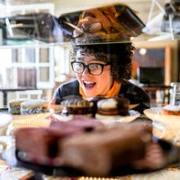 A young woman looks excitedly at pastries.