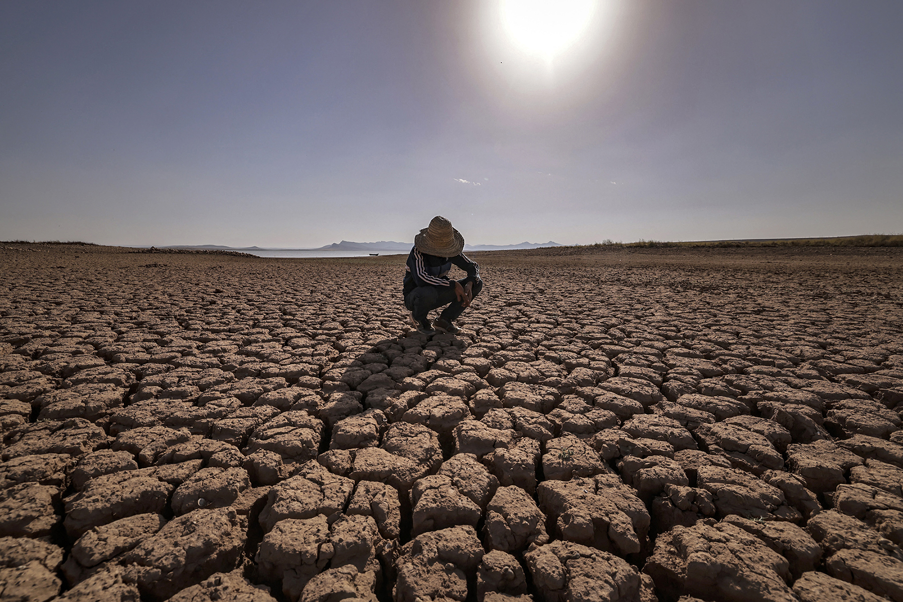 OULED ESSI MASSEOUD, MOROCCO: A child crouches at al-Massira dam in August 2022 amid the country’s worst drought in at least forty years. Experts say that worsening effects of climate change could increasingly contribute to refugee flows.